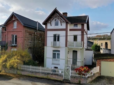 Karakteristiek woonhuis met garage en tuin.